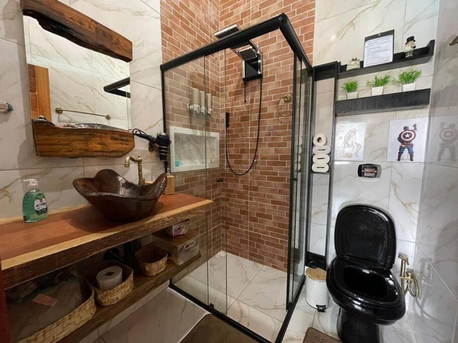 a bathroom with a sink and a glass shower at recanto do sossego. in Sinop