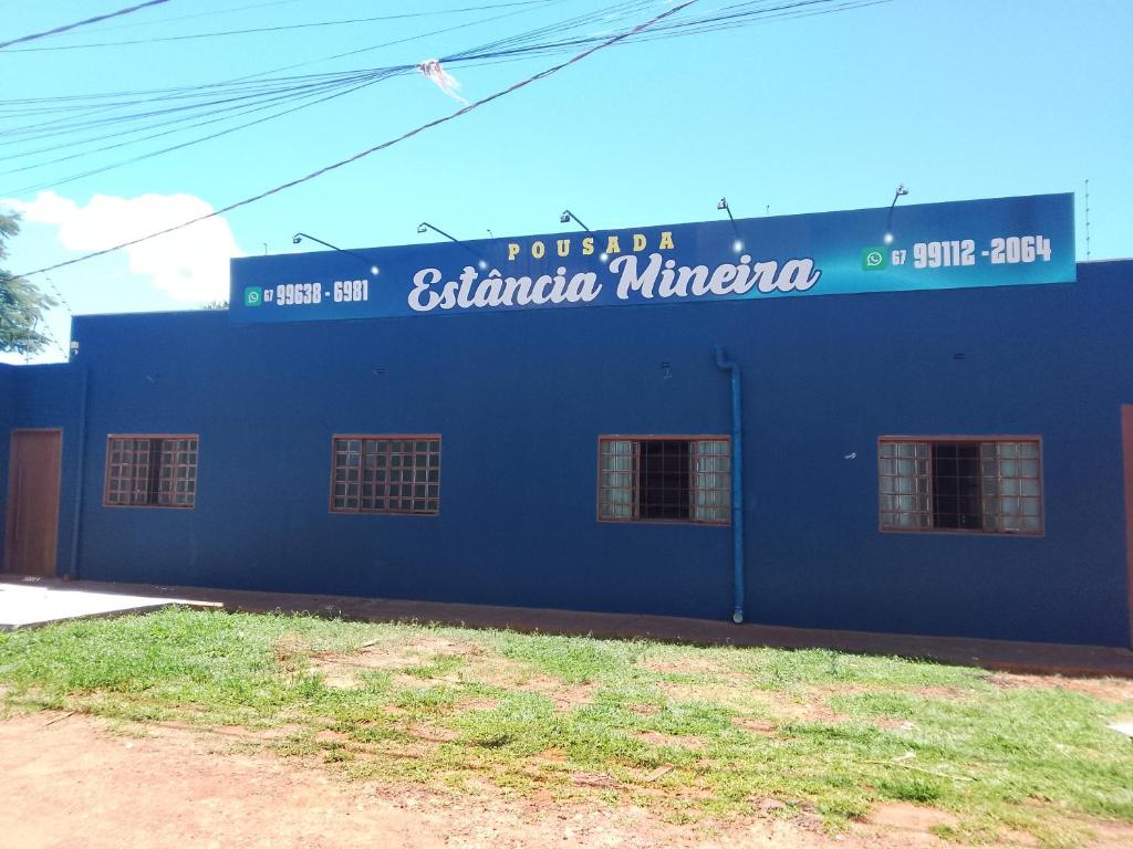 a blue building with a sign on the side of it at Pousada Estância Mineira in Campo Grande