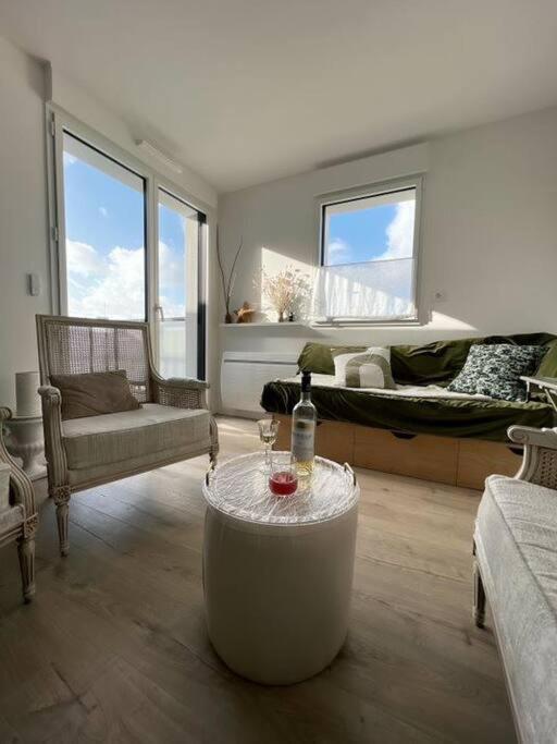 un salon avec une bouteille de vin sur une table dans l'établissement Gwiskaou A 170m de la plage, à Concarneau