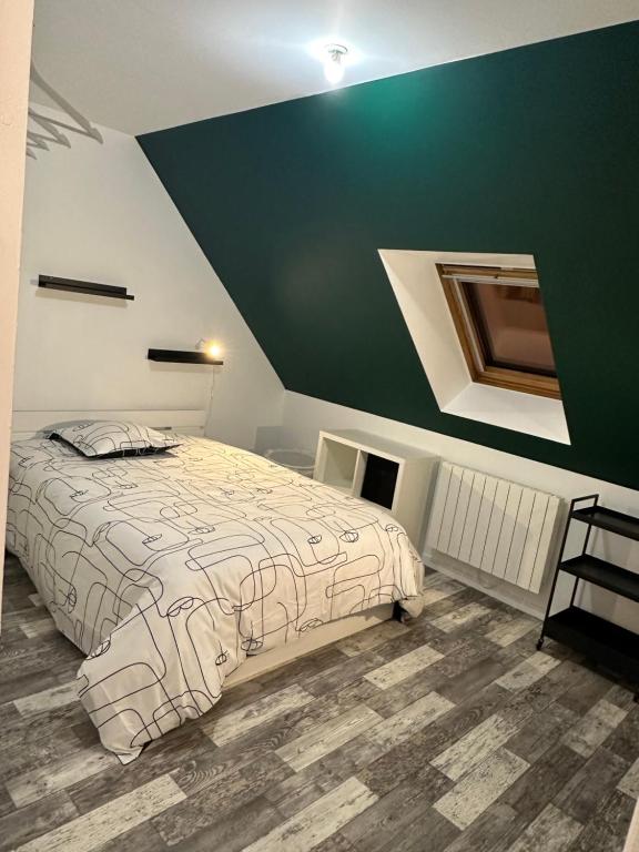 1 dormitorio con cama y pared verde en The GREEN HOUSE, en Saint-Brieuc