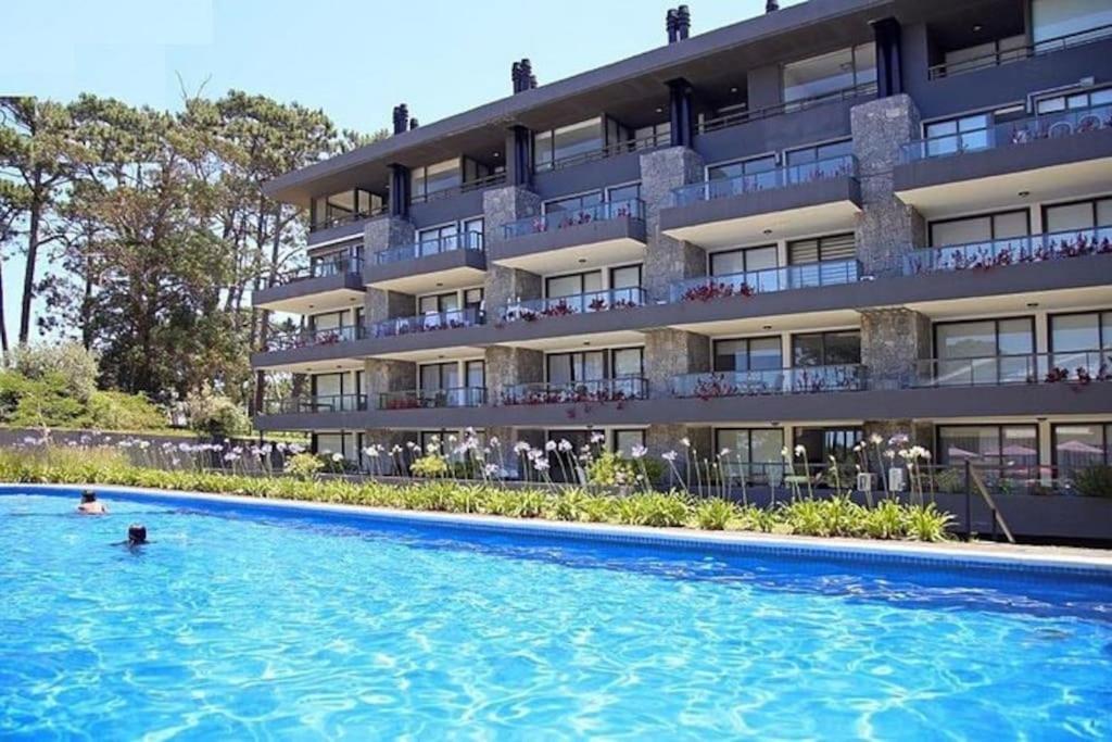 un hotel con piscina frente a un edificio en Edificio Unique en Punta del Este