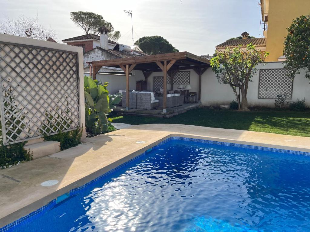 a swimming pool in the backyard of a house at Chalet Ciudad Ducal con piscina y jardin in El Puerto de Santa María