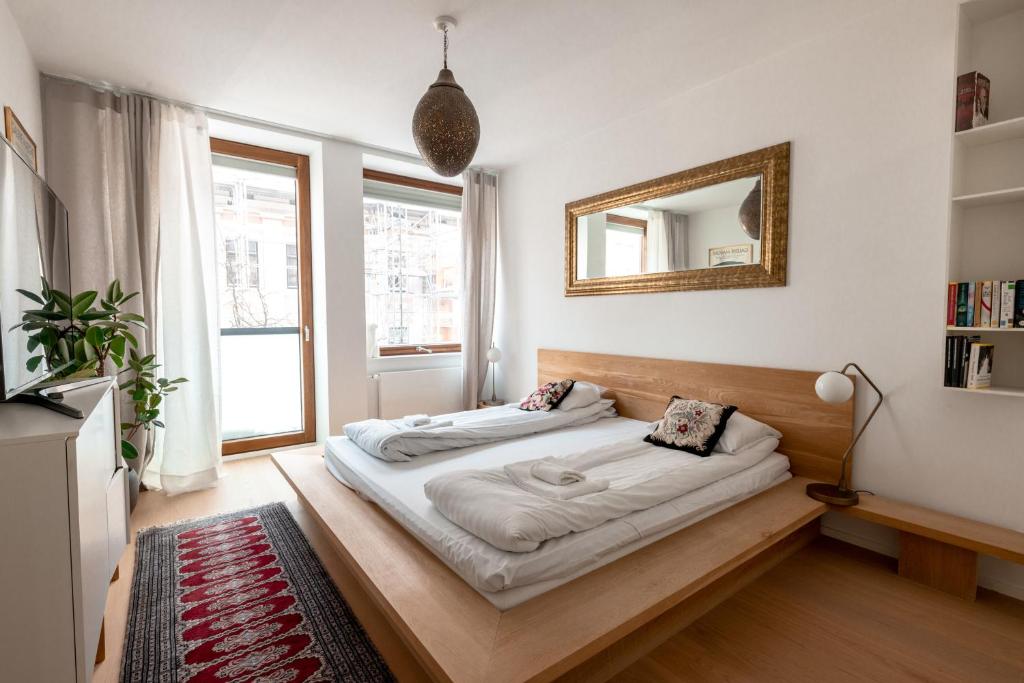 2ndhomes Gorgeous and Modern 2BR Apartment with Balcony في هلسنكي: غرفة نوم مع سرير ومرآة على الحائط