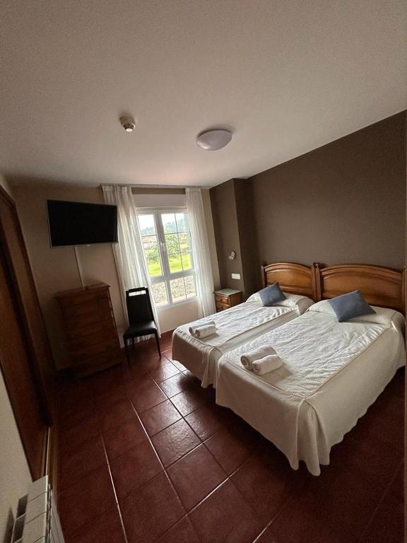 a bedroom with a large bed and a television at Hotel Restaurante el Fornon in Novellana