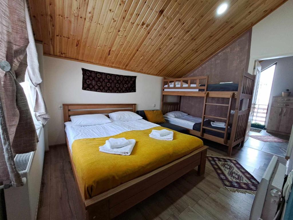 古道里的住宿－Cottage in Gudauri，一间卧室配有黄色的床和毛巾