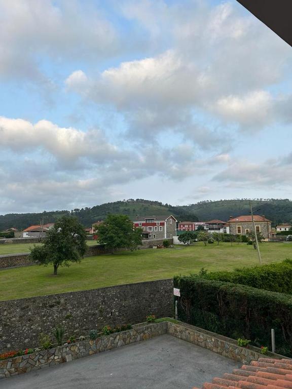 a view of a field with houses in the background at Hotel Restaurante el Fornon in Novellana