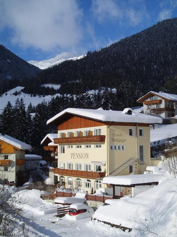 un gran edificio en la nieve con una montaña en Pension Bichlgeiger, en Anras