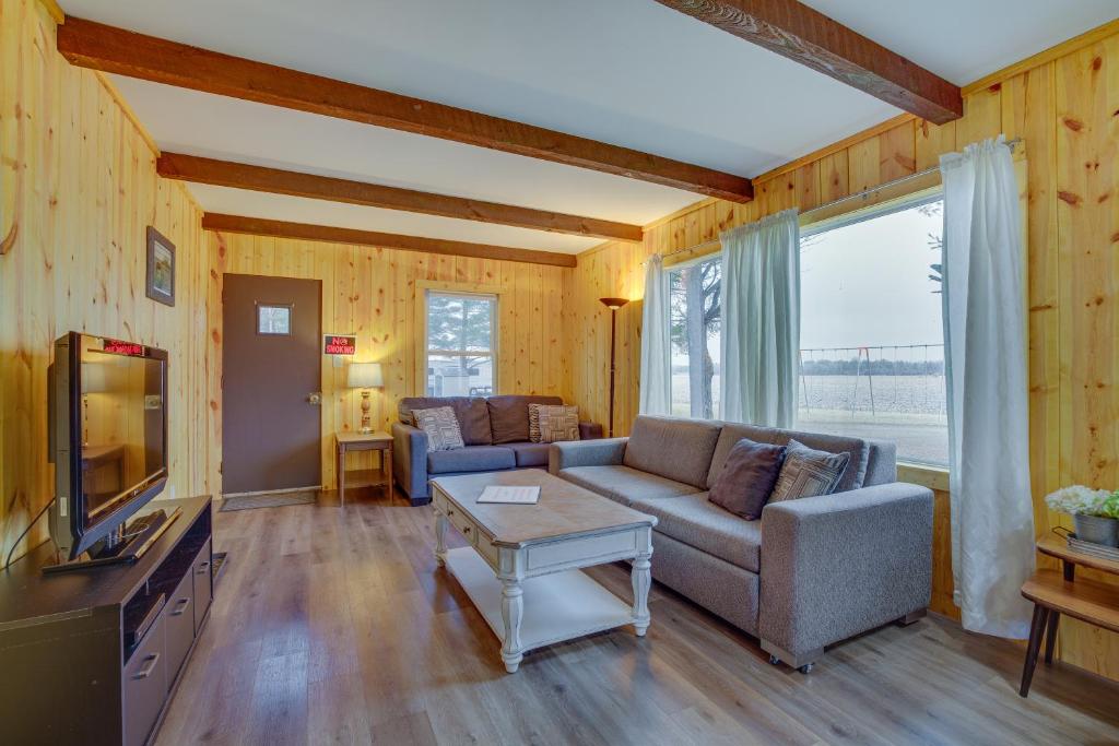 a living room with a couch and a tv at Pet-Friendly Cabin Retreat Wisconsin River Access in Lyndon Station