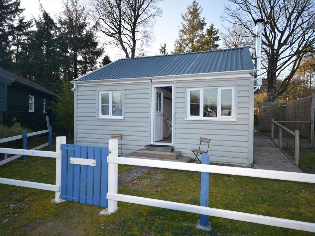 a small white shed with a porch and a fence at 1 bed in Llansteffan 74267 in Ferryside