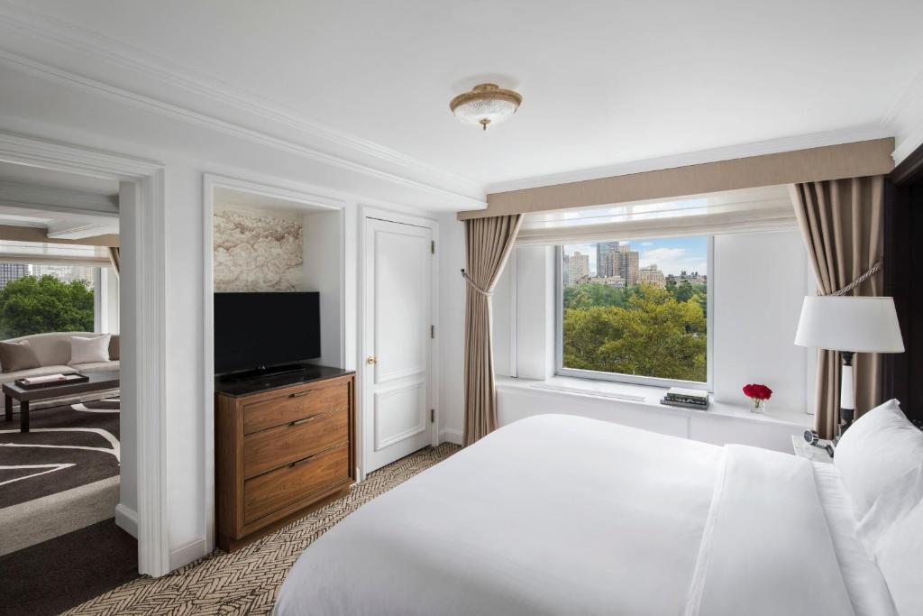 a hotel room with a bed and a television at The Ritz-Carlton New York, Central Park in New York