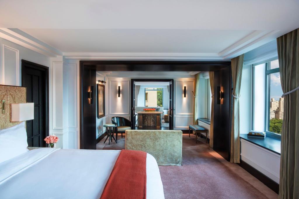 a bedroom with a bed and a living room at The Ritz-Carlton New York, Central Park in New York