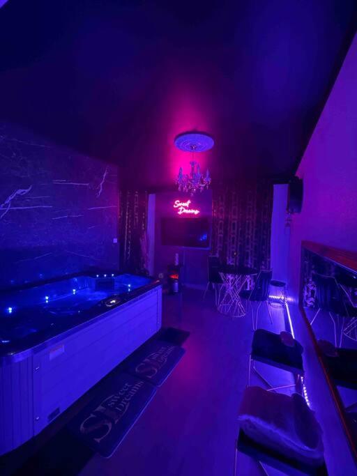 une chambre avec une baignoire dans une pièce violette dans l'établissement APPARTEMENT AVEC SPA (55m2) ENTRÉE AUTONOME, à Stiring-Wendel