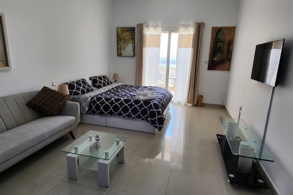 a living room with a bed and a couch at Home away from Home in Ras al Khaimah