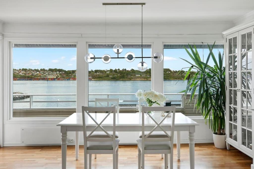 a dining room with a white table and chairs at 3-bedroom terrace house with incredible sea views in Moss