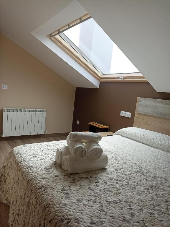 a bedroom with a large bed with a skylight at Hotel Restaurante el Fornon in Novellana