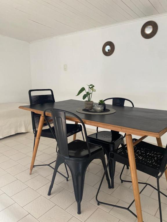 una mesa de madera con sillas negras y una mesa con una planta. en Amelie en General Roca