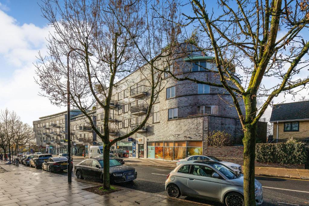 a street with cars parked in front of a building at 2 Bed Apartment in West Hampstead in London