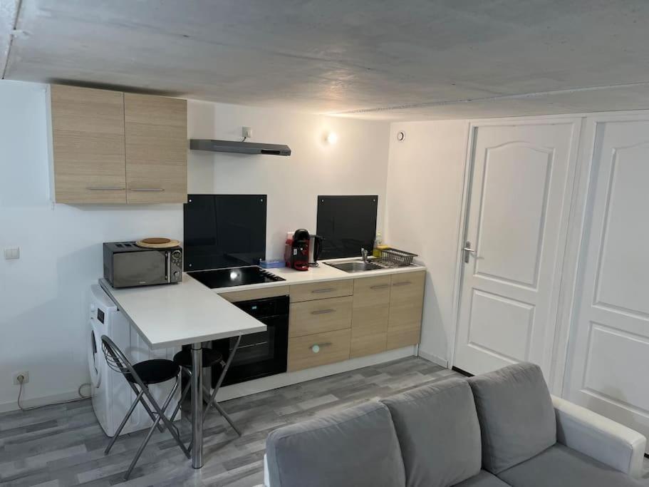 a kitchen with a couch and a table in a room at Appartement Souplex, Cholet in Cholet