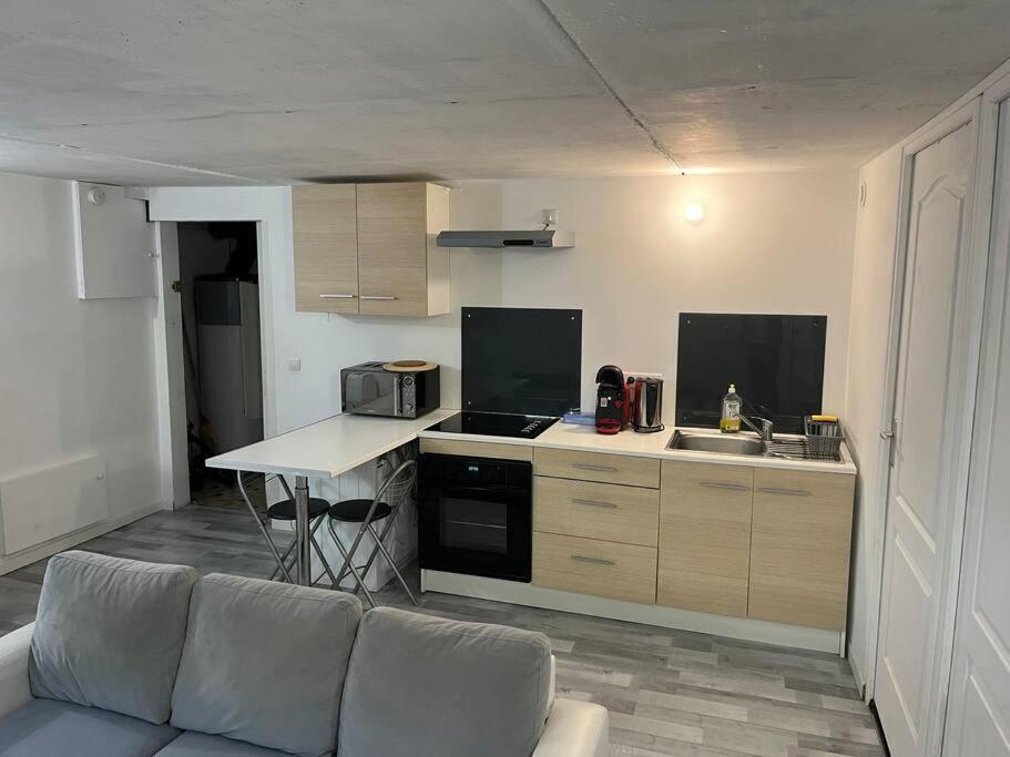 a living room with a couch and a kitchen at Appartement Souplex, Cholet in Cholet