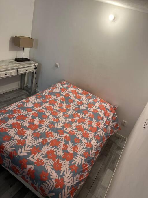 a bedroom with a bed with a flowered blanket at Appartement Souplex, Cholet in Cholet