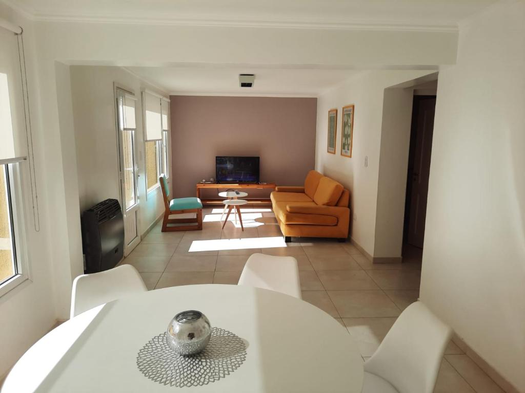 un soggiorno con tavolo e sedie bianchi di La Fragua Suites Líbano a El Bolsón