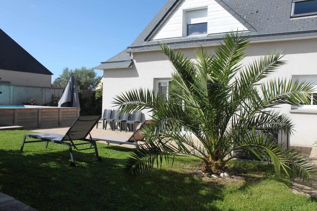 een palmboom in een tuin naast een huis bij Grande maison de vacances in Agon Coutainville