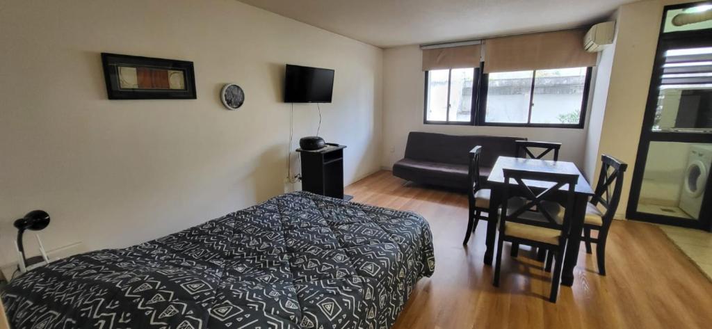 - une chambre avec un lit, une table et un canapé dans l'établissement Amplio Studio en Pocitos, à Montevideo