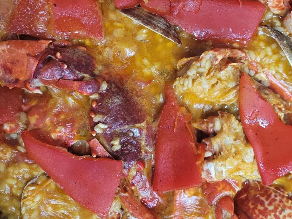 a close up of a pizza with tomatoes and other toppings at Hotel Restaurante el Fornon in Novellana