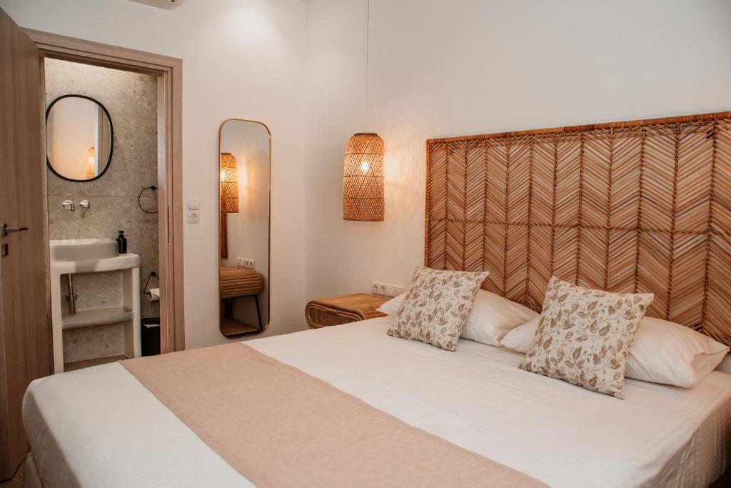 a bedroom with a large white bed with two pillows at Anais Of Naxos in Agia Anna Naxos