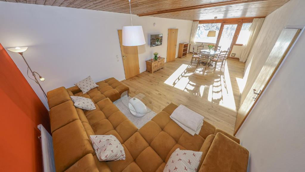 - un salon avec un grand canapé brun et une table dans l'établissement Appartement auf dem Schlossberg, à Fieberbrunn