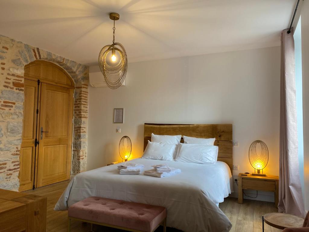 a bedroom with a large bed with two lamps at La Bellours Chambre D'Hôtes in Cahors