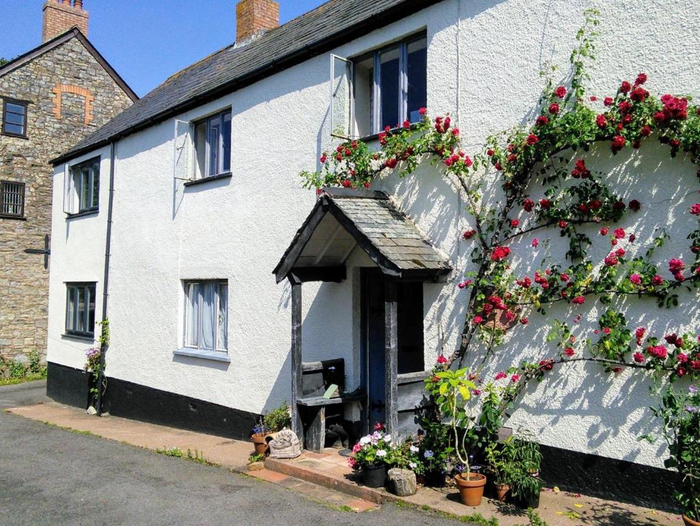 a white house with flowers on the side of it at 1 Bed in Kilve KILVE in Kilve
