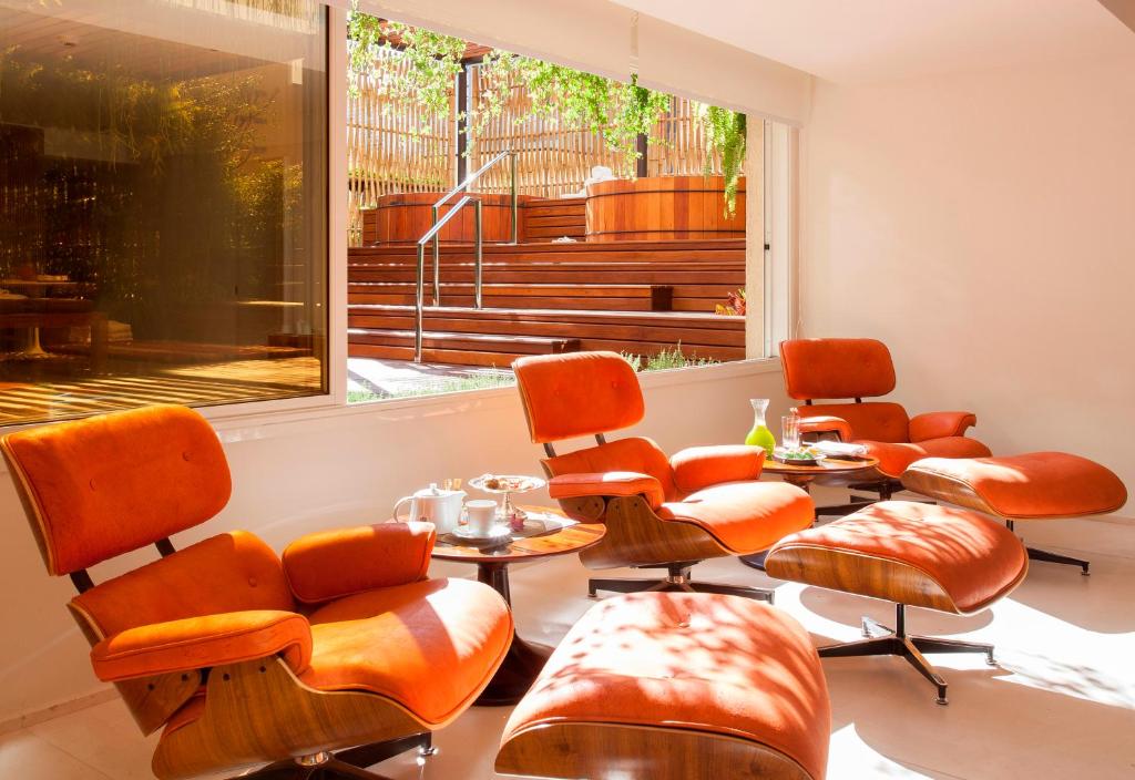 a waiting room with chairs and tables and a window at Hotel Emiliano in Sao Paulo