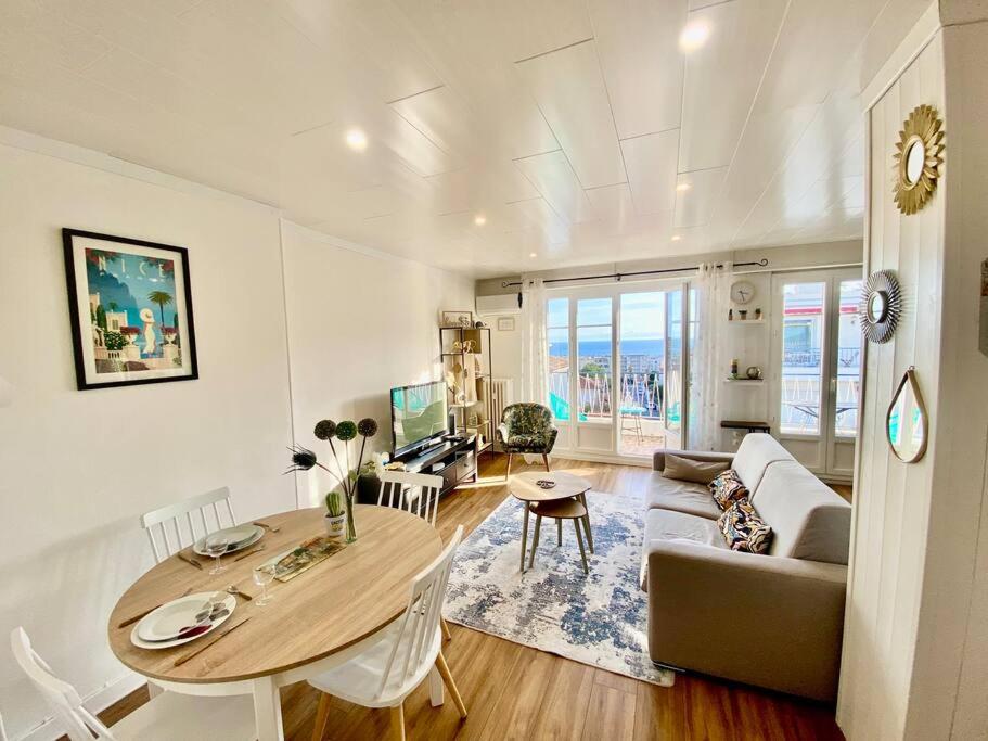un salon avec une table et un canapé dans l'établissement Nice 2P Vue Mer- 5min plage, Terrasse, AC, Parking, à Nice