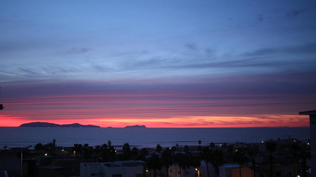 una puesta de sol sobre el océano y una ciudad en Spacious Tijuana Beach Home With Private Heated* Pool en Tijuana