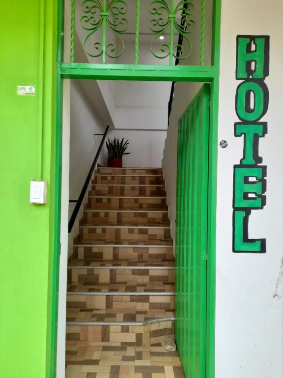 een trap met groene muren en een groene deur bij Hotel Puertas del Norte in Lorica