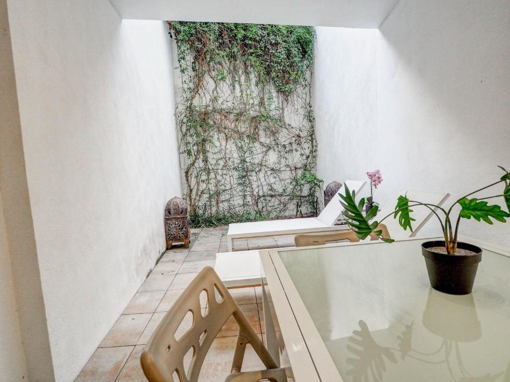 een kamer met een tafel en stoelen en een plant bij Luxe Apartment by Hello Homes Sitges in Sitges