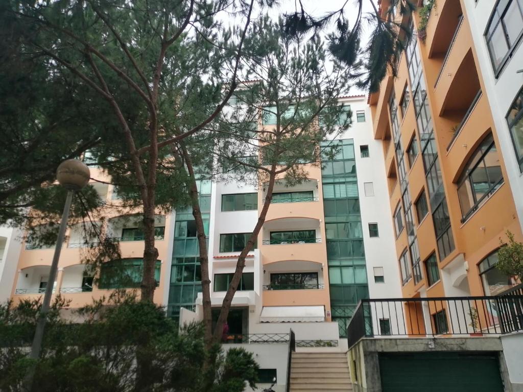an apartment building with trees in the foreground at Cascais Luxury Top Floor Apt in Cascais