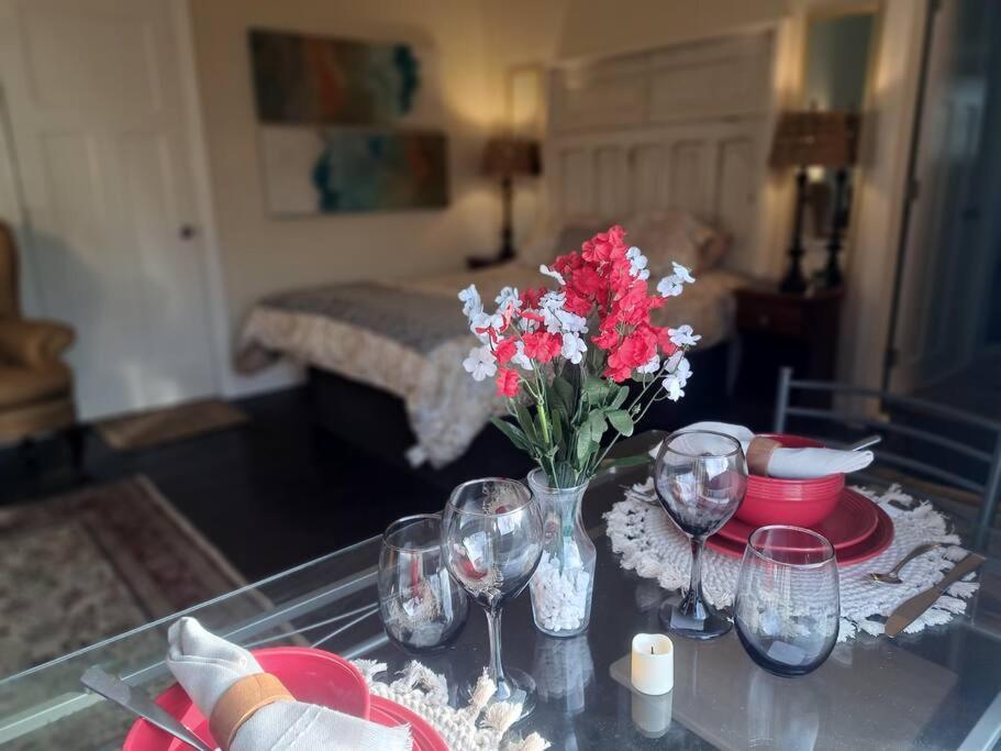 a table with wine glasses and a vase of flowers at Sunset Studio with Full Kitchen and no fee in Florence