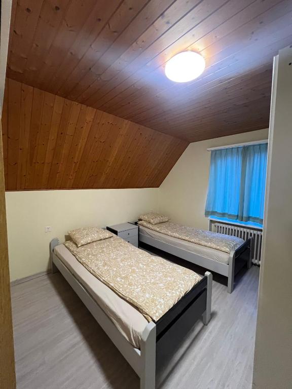 Niederdorf, Baselland Hotel في Niederdorf: سريرين في غرفة ذات سقف خشبي
