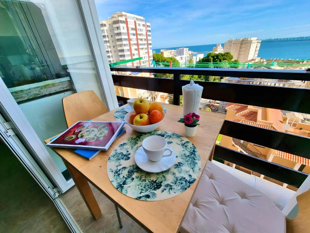 a table with a bowl of fruit on a balcony at Pleasant studio with sea view in Benalmádena, 30 m², pool in Benalmádena