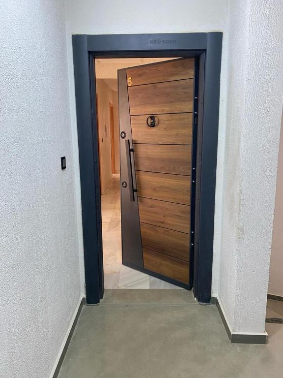 uma porta de madeira num quarto com um corredor em Appartement neuf et élégant em Fez