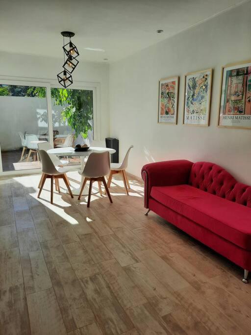 a living room with a red couch and a table at La Fragua Suites Saavedra in El Bolsón