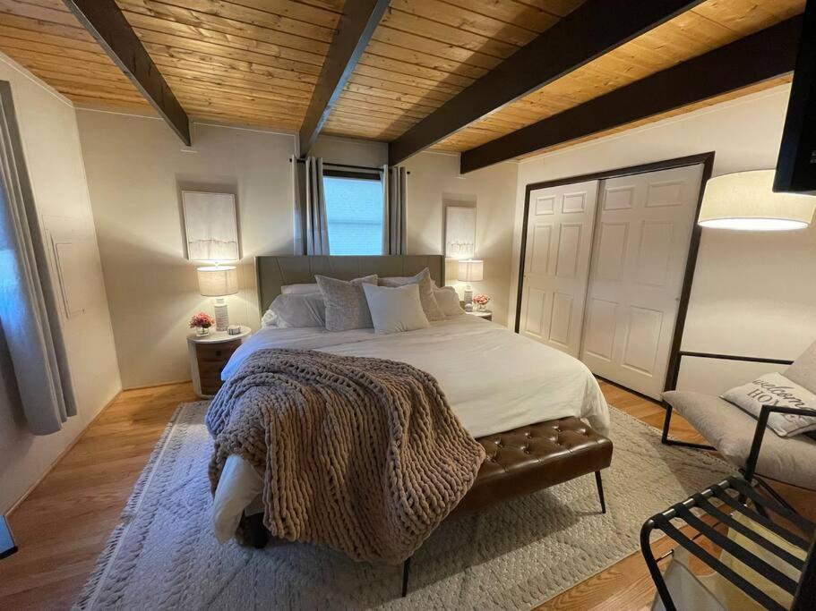 um quarto com uma cama grande e um sofá em Cozy Poconos retreat on Bushkill Creek w/ Firepit! em East Stroudsburg