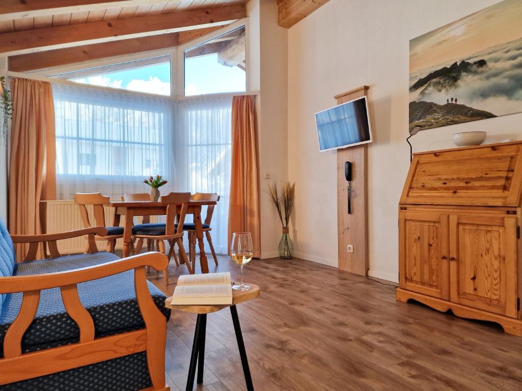 a living room with a table and a dining room at HoFer am Zeitberg Ferienwohnung Sonneck in Bad Kohlgrub