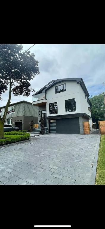 a large white house with a large driveway at 6 BEDROOM MODERN AND LUXURY HOME in Welland