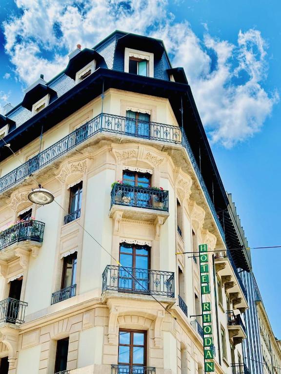 a tall white building with balconies and a blue sky at Rhodania Boutique Hôtel in Geneva