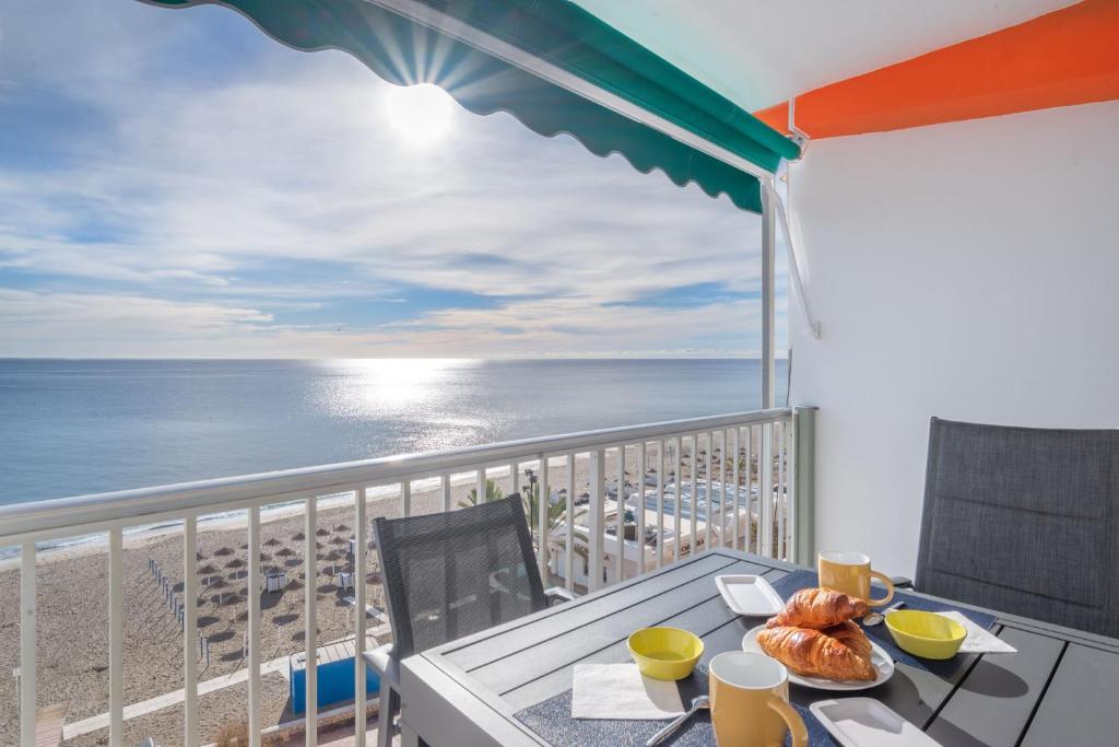 a balcony with a table with a view of the beach at Appartement PM 25 in Fuengirola