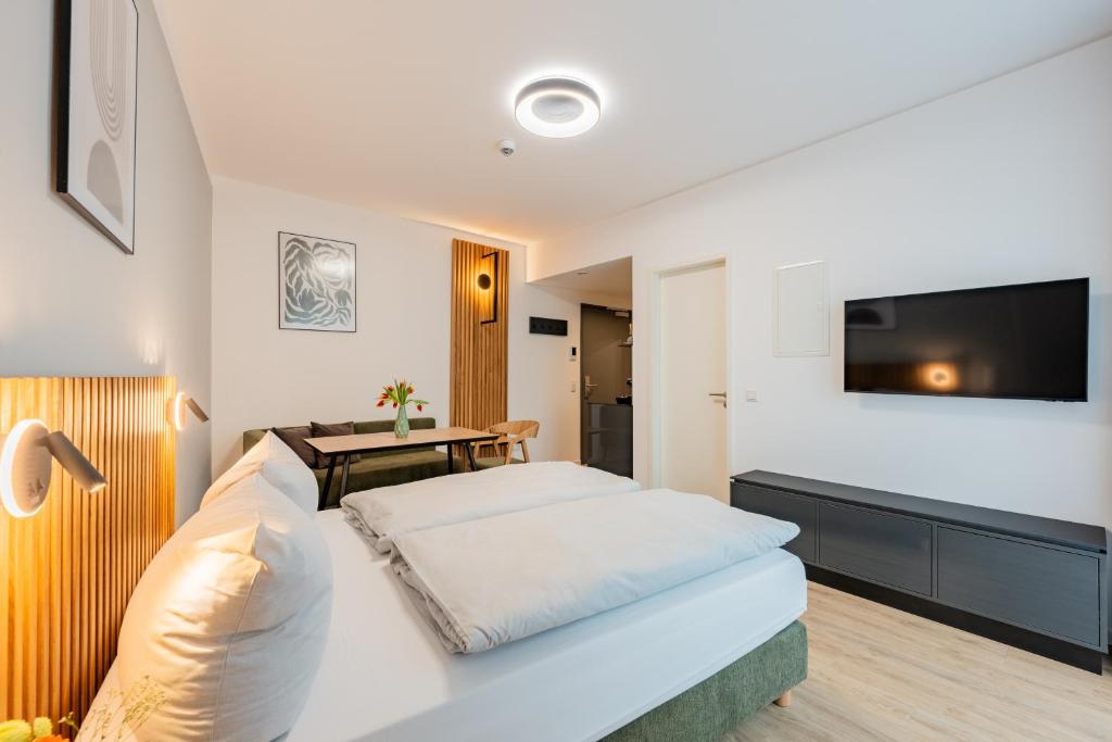 a bedroom with a bed and a tv on a wall at Nena Apartments Berlin - Adlershof - "New Opening 2024" in Berlin