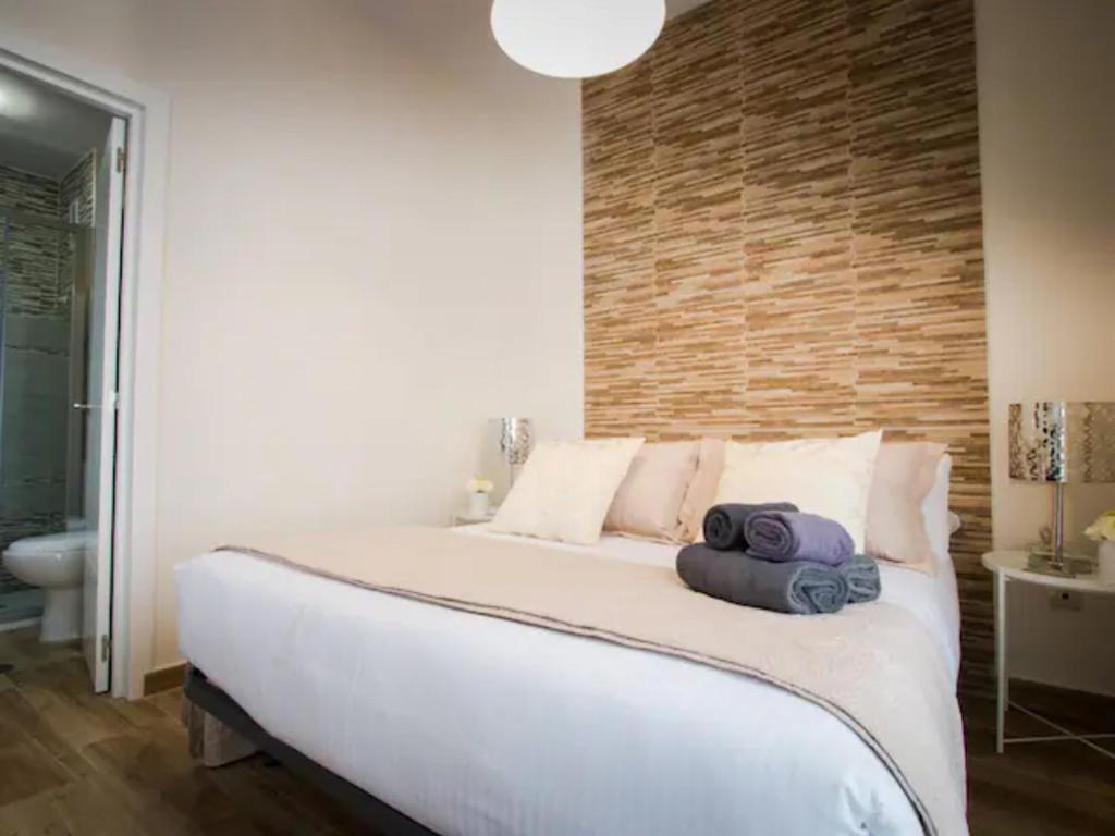 sypialnia z dużym łóżkiem i dwoma ręcznikami na nim w obiekcie Málaga centro bonito apartamento w Maladze